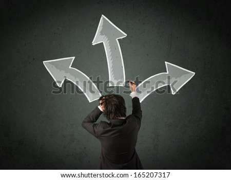 Young businessman taking a decision with different directed arrows above his head
