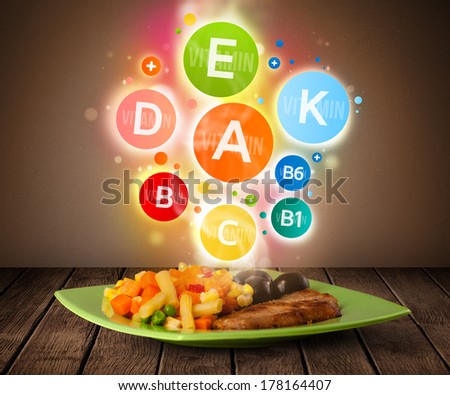 Food plate with delicious meal and healthy colorful vitamin symbols