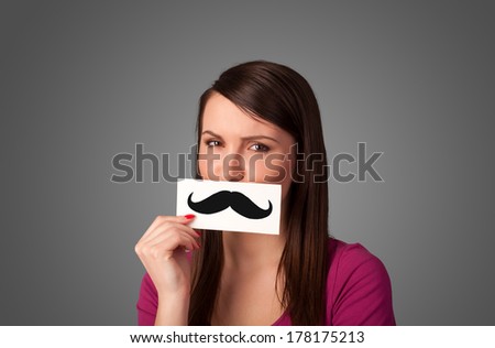 Happy cute girl holding paper with mustache drawing on gradient background