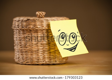 Drawn smiley face on a note stuck on a jewelry box