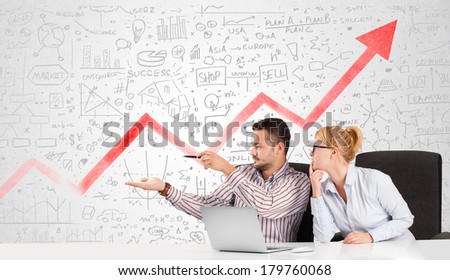 Business man and woman sitting at table with market hand drawn diagrams