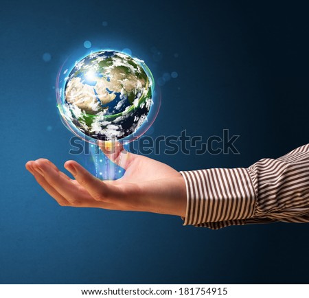 Young businessman holding in his hand a glowing earth globe, Elements of this image furnished by NASA