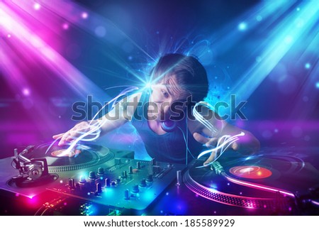 Young energetic Dj mixing music with powerful light effects