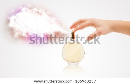 close up of woman hands spraying colorful cloud from beautiful perfume bottle
