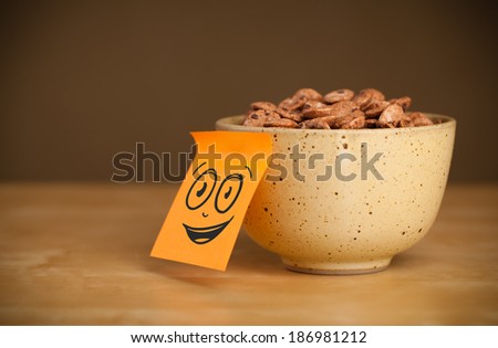 Drawn smiley face on a post-it note sticked on a cereal bowl