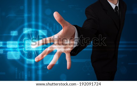 Young businessman pressing high tech type of modern buttons