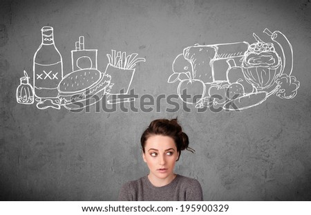 Pretty young woman choosing between healthy and unhealthy foods