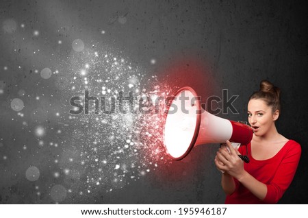 Woman shouting into megaphone and glowing energy particles explode concept