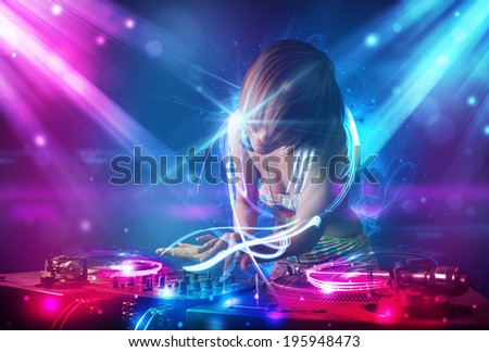 Energetic Dj girl mixing music with powerful light effects