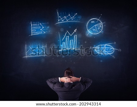 Young businessman standing in front of glowing charts and diagrams