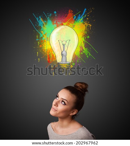 Pretty young woman gesturing with lightbulb and paint splashes above her head