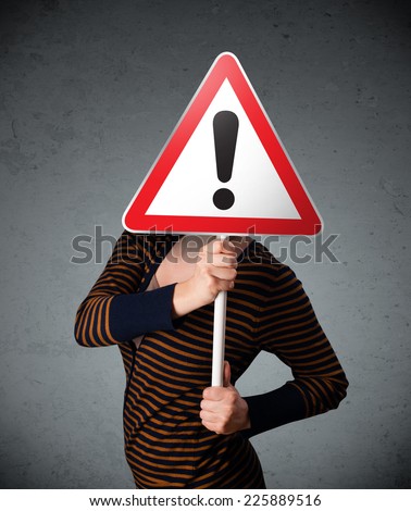 Young woman holding a red traffic triangle warning sign in front of her head