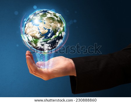 Young businessman holding in his hand a glowing earth globe, Elements of this image furnished by NASA