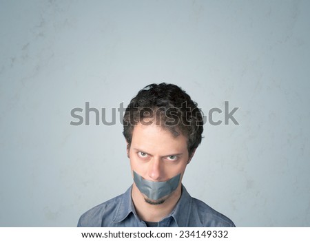 Young man with taped mouth. Isolated on gray background