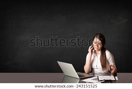 Businesswoman sitting at black table with a laptop on black background