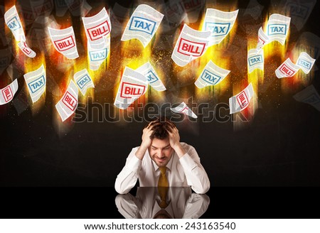 Depressed businessman sitting under falling papers