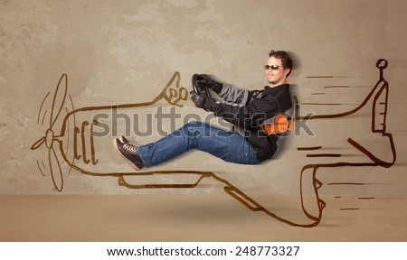 Funny pilot driving a hand drawn airplane on the wall concept