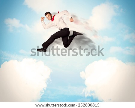 Business person jumping over clouds in the blue sky concept