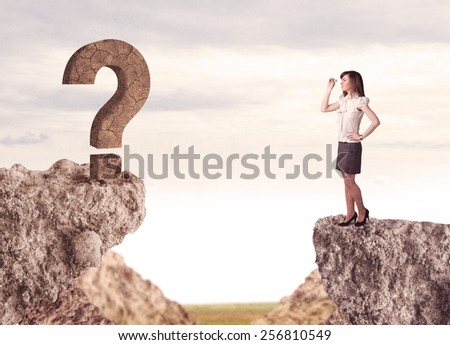 Businesswoman standing on the edge of mountain with a rock question mark on the other side