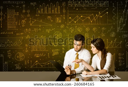 Business couple sitting at black table with hand drawn diagram background