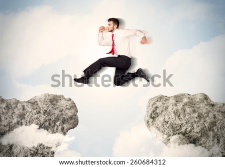 Happy business man jumping over a cliff concept