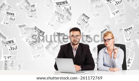 Business man and woman at desk with stock market newspapers concept