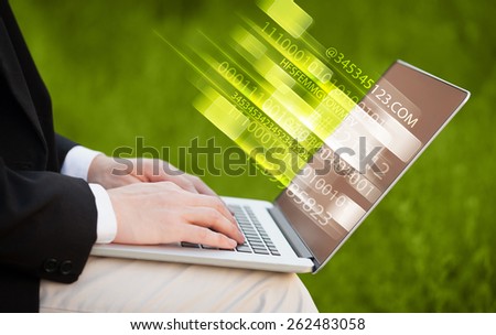 Close up of man typing on laptop computer with glowing technology effect