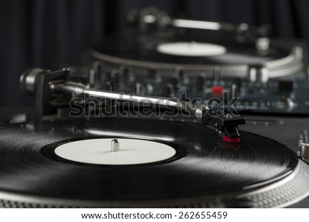 Turntable playing vinyl close up with needle on the record with grey background