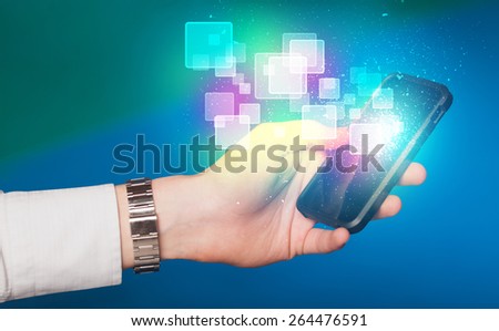 Hand holding smart phone with abstract glowing squares concept