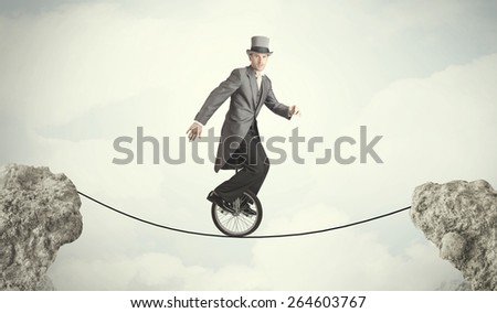 Brave business man riding an mono cycle between cliffs concept