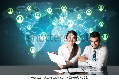 Business couple sitting at table with social media connection symbols on the world map