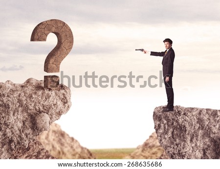 Businessman standing on the edge of mountain with a rock question mark on the other side