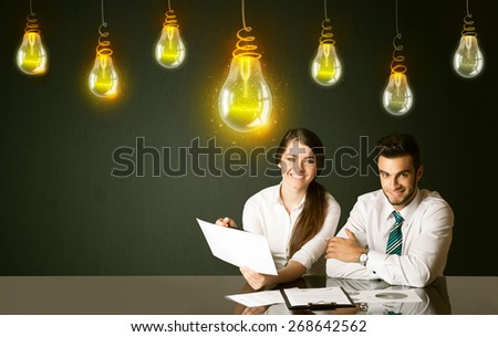 Business couple sitting at the black table with idea bulbs on the background