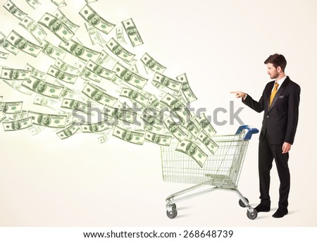 Businessman pushing a shopping cart and dollar bills coming out of it