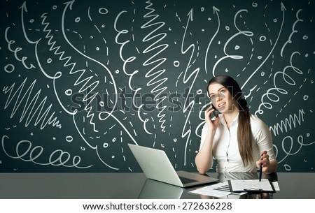 Businesswoman sitting at table with drawn curly lines and arrows on the background