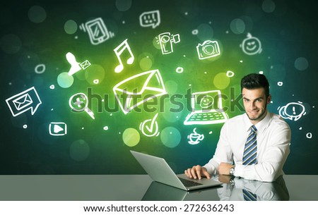 Businessman sitting at the black table with social media symbols on the background