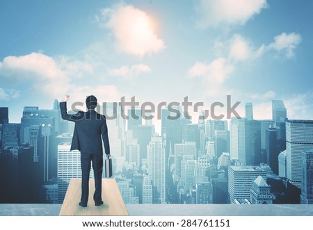 Businessman standing on a roof and looking at future city
