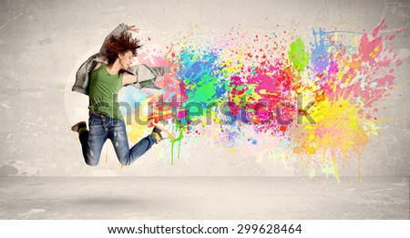 Happy teenager jumping with colorful ink splatter on urban background concept