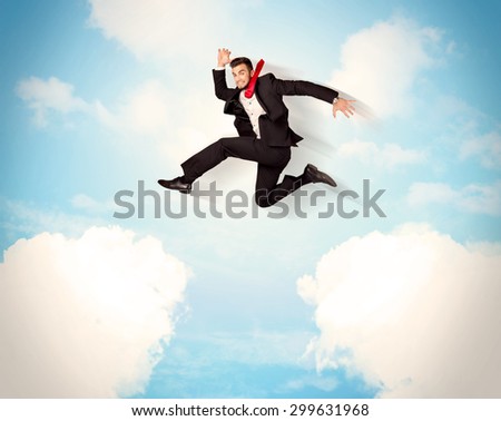 Business person jumping over clouds in the blue sky concept