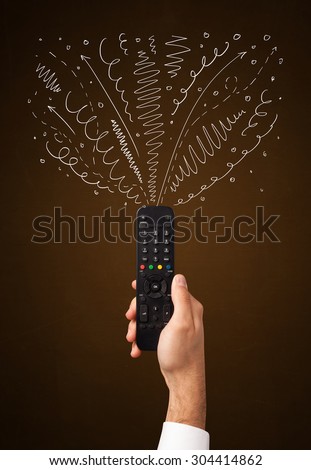 Hand holding a remote control, curly lines and arrows coming out of it