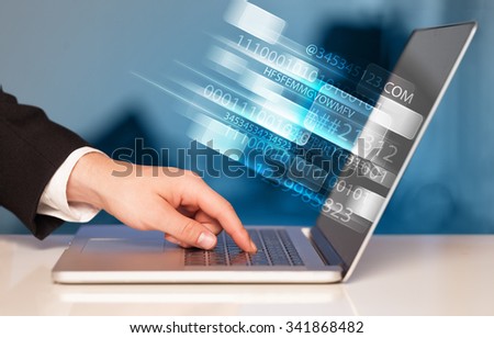 Close up of man typing on laptop computer with glowing technology effect