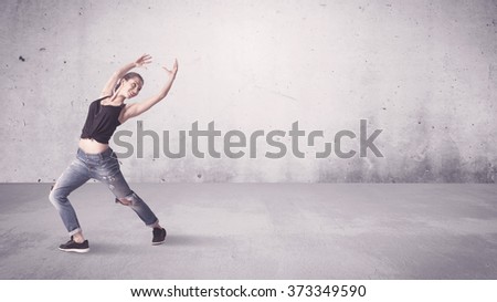 A beautiful young hip hop dancer dancing contemporary urban street dance in empty clear grey wall background concept.