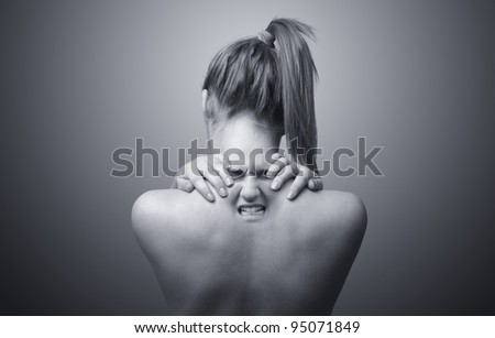 A nude back of a woman indicating neck pain