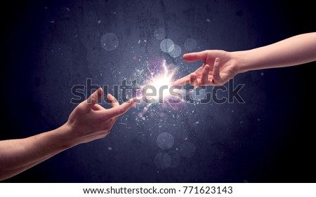 Two male hands reaching towards each other, almost touching with fingers, lighting spark in galaxy background concept
