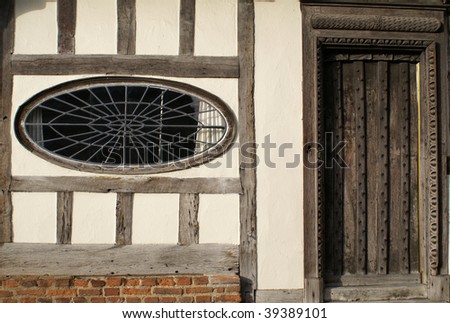 Door and rare oval window of timber-framed Tudor-style house in Saffron Walden