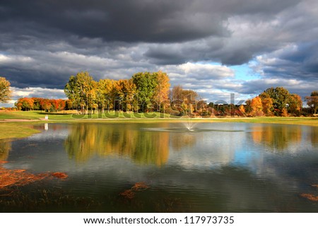 Golf course with autumn tree reflections
