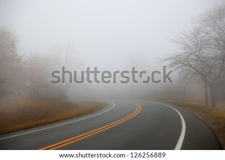 Nice winding road caught in the fog in winter time