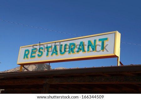 Restaurant board against blue sky