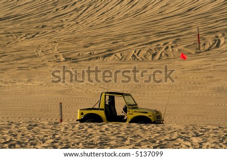 Single off road vehicle parked in the middle of desert