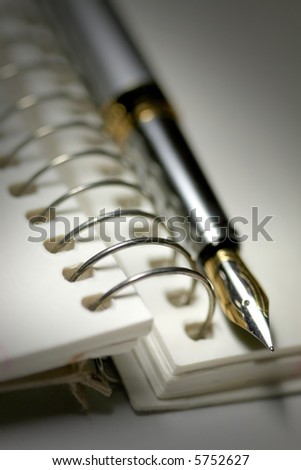 Black and white image of Pen and spiral bound book